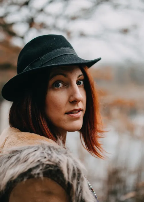 Portrait de Virginie, praticienne en constellations familiales à Castres, chapeau noir, en extérieur à l'automne